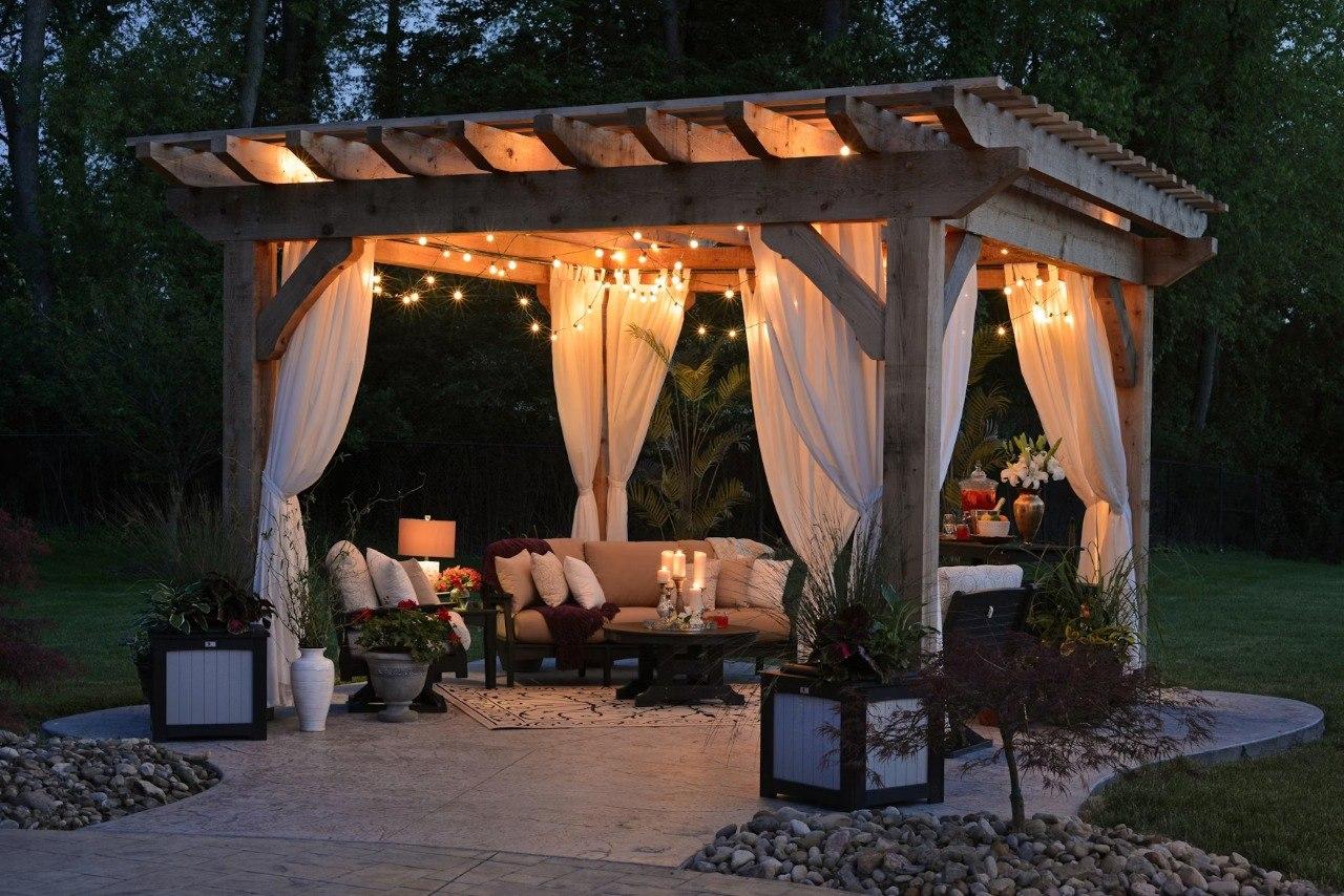 Custom concrete patio with pergola and string lights in Kansas City backyard